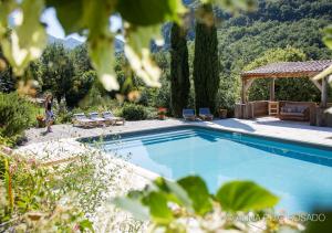 a swimming pool with chairs and a gazebo at La Maison de Marguerite in Montbrun-les-Bains