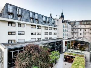 an apartment building with a garden in front of it at Hotel Grauer Bär in Innsbruck