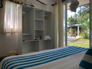 a bedroom with a bed with blue and white stripes at Ocean Caves, Balapitiya in Balapitiya