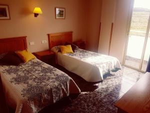una camera d'albergo con due letti e una finestra di Hotel Sonia Chipude a El Cercado
