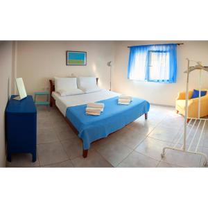 a bedroom with a large bed with a blue blanket at K Residences in Elaiokhórion