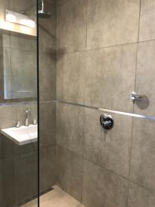 a bathroom with a shower with a sink at BOULEVARD departamentos in Mina Clavero +66 photos