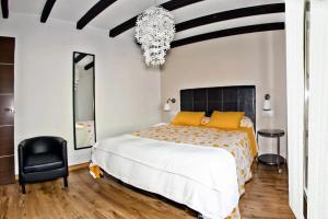 a bedroom with a large bed and a chandelier at Apartamentos El Roble in Valverde de la Vera +46 photos