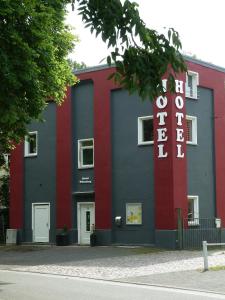 ein rotes weißes und blaues Gebäude mit einem Schild in der Unterkunft Hotel Wittenberg-Hotel Garni in Lutherstadt Wittenberg