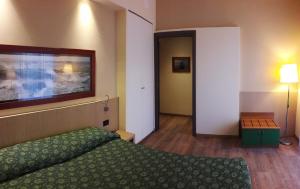 a hotel room with a green bed and a hallway at Hotel Esperia in Genoa