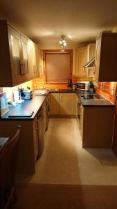a large kitchen with wooden cabinets and counters at Castleyards Apartment 12 in Kirkwall