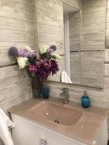 a bathroom with a sink with a vase of flowers at Apartamento City SOLO ADULTOS in Madrid