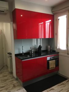a red kitchen with black counters and red cabinets at Apartamento City SOLO ADULTOS in Madrid