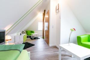 ein Wohnzimmer mit grünen Möbeln und einer Treppe in der Unterkunft Ferienwohnung Alexandra in Heilbad Heiligenstadt