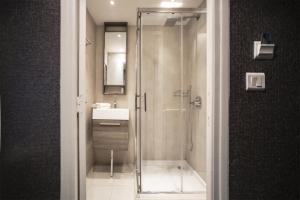 a bathroom with a shower and a sink at Hotel Schtak in Cannes +21 photos