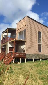 una casa che è seduta sopra un campo di Arachania al Mar a Costa Azul