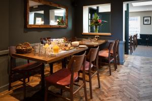 a dining room with a table with food and a mirror at The Inn West End in Woking