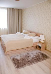 a bedroom with a large bed and a rug at Penzion Jollien in Námestovo