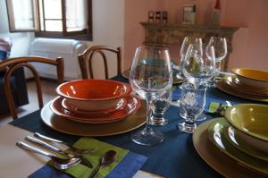 Una mesa con platos y copas de vino encima. en La Scarana, en Ferrara
