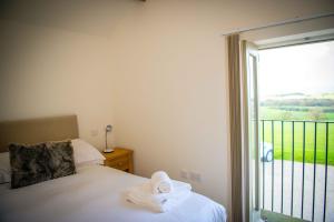 a bedroom with a bed next to a sliding glass door at The Hayloft in Skipton