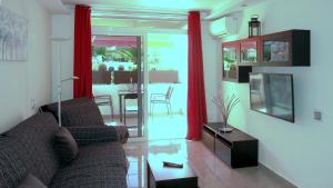 コスタ・デル・シレンチオにあるVictory South Tenerifeのリビングルーム(ソファ、テーブル、テレビ付)