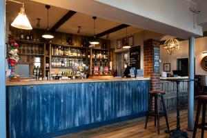 a bar with a blue counter and some bottles at The Inn West End in Woking