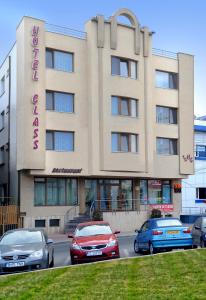 un edificio con coches estacionados frente a él en Hotel Class, en Constanţa