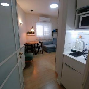 uma cozinha e uma sala de estar com uma mesa em Ramat Poleg, walk to beach em Netanya