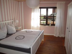 1 dormitorio con 1 cama blanca grande y ventana en Ferienhaus Elbblick, en Tangermünde
