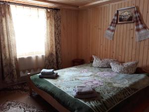- une chambre avec un lit dans une pièce dotée d'une fenêtre dans l'établissement Яблуневий сад, à Yablunytsya