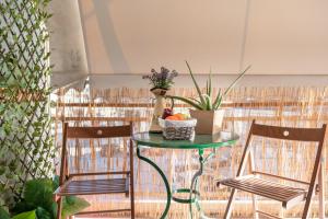 a green table with two chairs and a basket of fruit at Izabella Guest House in Nafplio