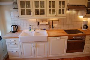 a kitchen with white cabinets and a sink and a stove at Schillers Stadthaus in Hitzacker