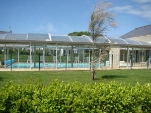 um edifício com uma piscina num quintal em Lagrange Vacances Le Hameau De Peemor Pen em Crozon