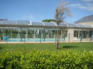 un edificio con piscina en un patio en Lagrange Vacances Le Hameau De Peemor Pen, en Crozon