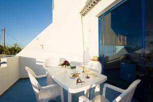 een witte tafel en stoelen op een balkon bij Costa Agaete - Puerto de las Nieves in Puerto de las Nieves