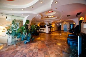 a lobby with plants and a ceiling with lights at Hotel Class in Constanţa
