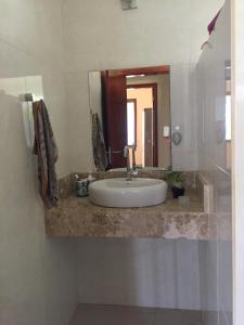 a bathroom with a sink and a large mirror at Casa de praia itacimirim in Itacimirim