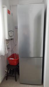 LupeniにあるApartament STRAJA Lupeni -regim self-cateringの- キッチン(白い冷蔵庫、赤いバスケット付)
