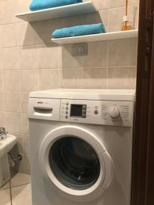 Una lavadora en un baño con toallas en los estantes. en Alloggio turistico Maison S Anselme VDA Aosta CIR 0015, en Aosta