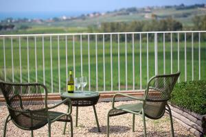 two chairs and a table with a bottle of wine at La Foresteria Planeta Wine Resort & Beach Club in Menfi