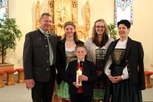 grupa ludzi stojących w kościele z chłopcem trzymającym świecę w obiekcie MBZ Birg 1414 w mieście Warth am Arlberg