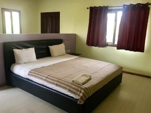 1 cama grande en un dormitorio con 2 ventanas en Omanye Lodge en Accra