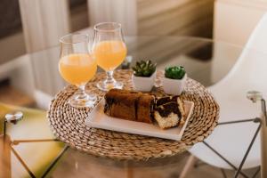 a table with a plate of cake and two glasses of orange juice at Casa Nuestra in Córdoba