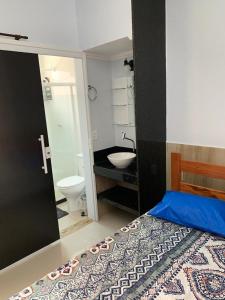 uma casa de banho com uma cama, um lavatório e um WC. em CASA PÔR DO SOL 1 em Arraial do Cabo