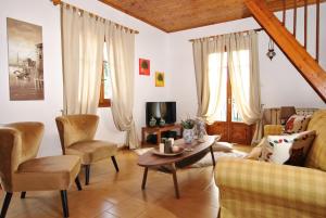 La Nonna Efrosini في Anomeriá: غرفة معيشة مع أريكة وكراسي وطاولة
