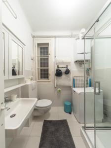 a white bathroom with a toilet and a sink at Artissimo Apartments in Zagreb