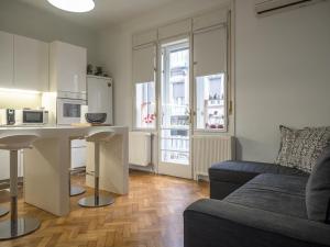 a kitchen and living room with a couch and a table at Artissimo Apartments in Zagreb
