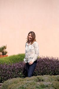 a woman standing in front of some purple bushes at La Foresteria Planeta Wine Resort & Beach Club in Menfi