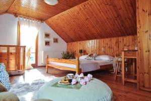 ein Zimmer mit 2 Betten und einem Tisch mit Blumen darauf in der Unterkunft La Nonna Efrosini in Anomeriá