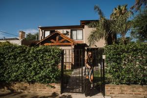 une femme debout derrière une porte devant une maison dans l'établissement Casa Nuestra, à Córdoba