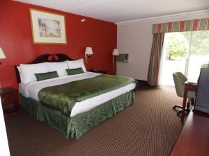 ein Hotelzimmer mit einem großen Bett mit roten Wänden in der Unterkunft Center Street Value Inn in Auburn