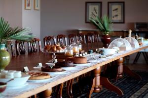 a long table with cookies and pastries on it at La Foresteria Planeta Wine Resort & Beach Club in Menfi