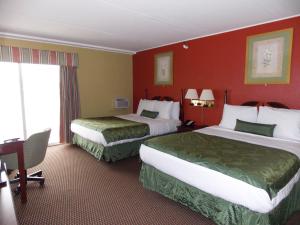 2 camas en una habitación de hotel con paredes rojas en Center Street Value Inn, en Auburn