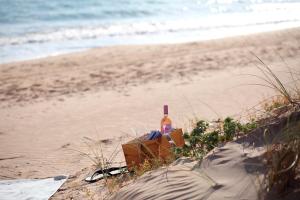 a bottle of alcohol sitting on the beach at La Foresteria Planeta Wine Resort & Beach Club in Menfi