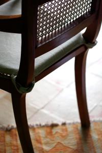 una sedia in legno seduta sopra un tappeto di La Foresteria Planetaestate a Menfi